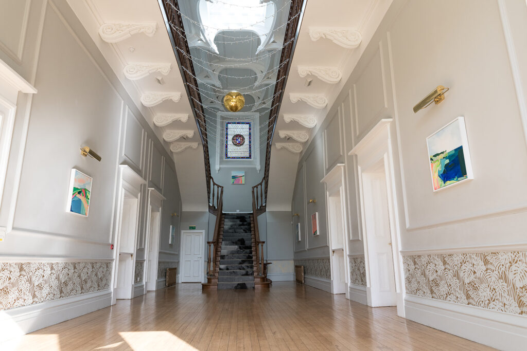 The Grand Hall at Netherbyres displaying brightly coloured abstract artworks by artist Hollie Savory