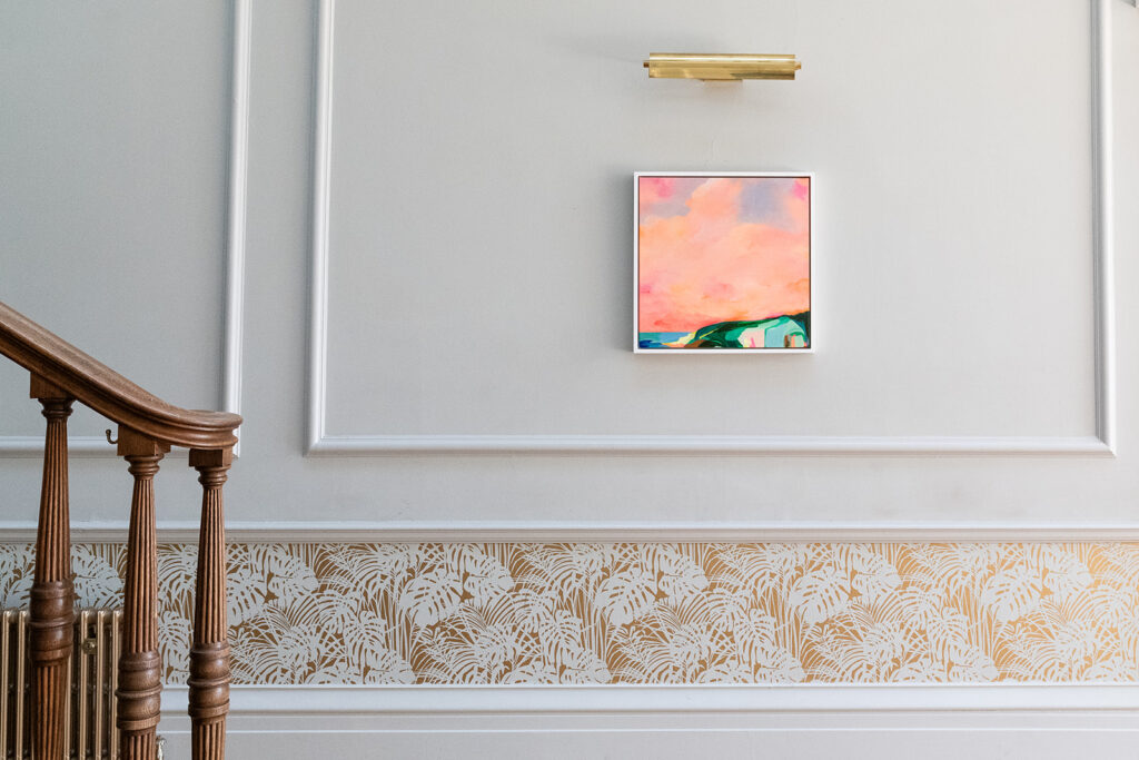 A brightly coloured abstract landscape artwork on a grey wall